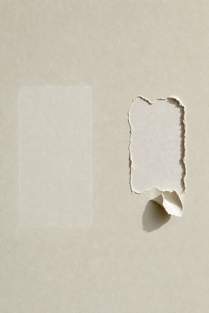 Two wall patches compared one where a strip came off cleanly and one where it tore the paint